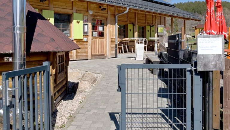 Offene Eingangstür zum SPASS-PARK-SCHLUCHSEE. Im Hintergrund Event-Scheune. Links eine Grill-Kota.