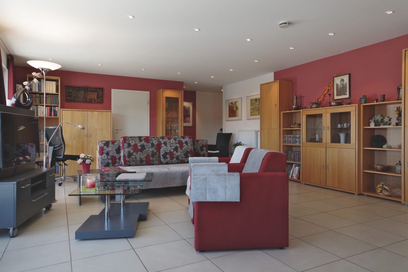 Wohnzimmer Il Paradiso links Fernseher, in der Mitte Schlafsofa, 2 Sessel und rechts Holzvitrinen.