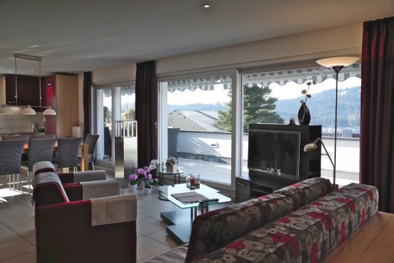 Wohnzimmer vom Il Paradiso mit Blick auf die Terrasse. Im Hintergrund sieht man das gegenüberliegende Ufer vom Schluchsee